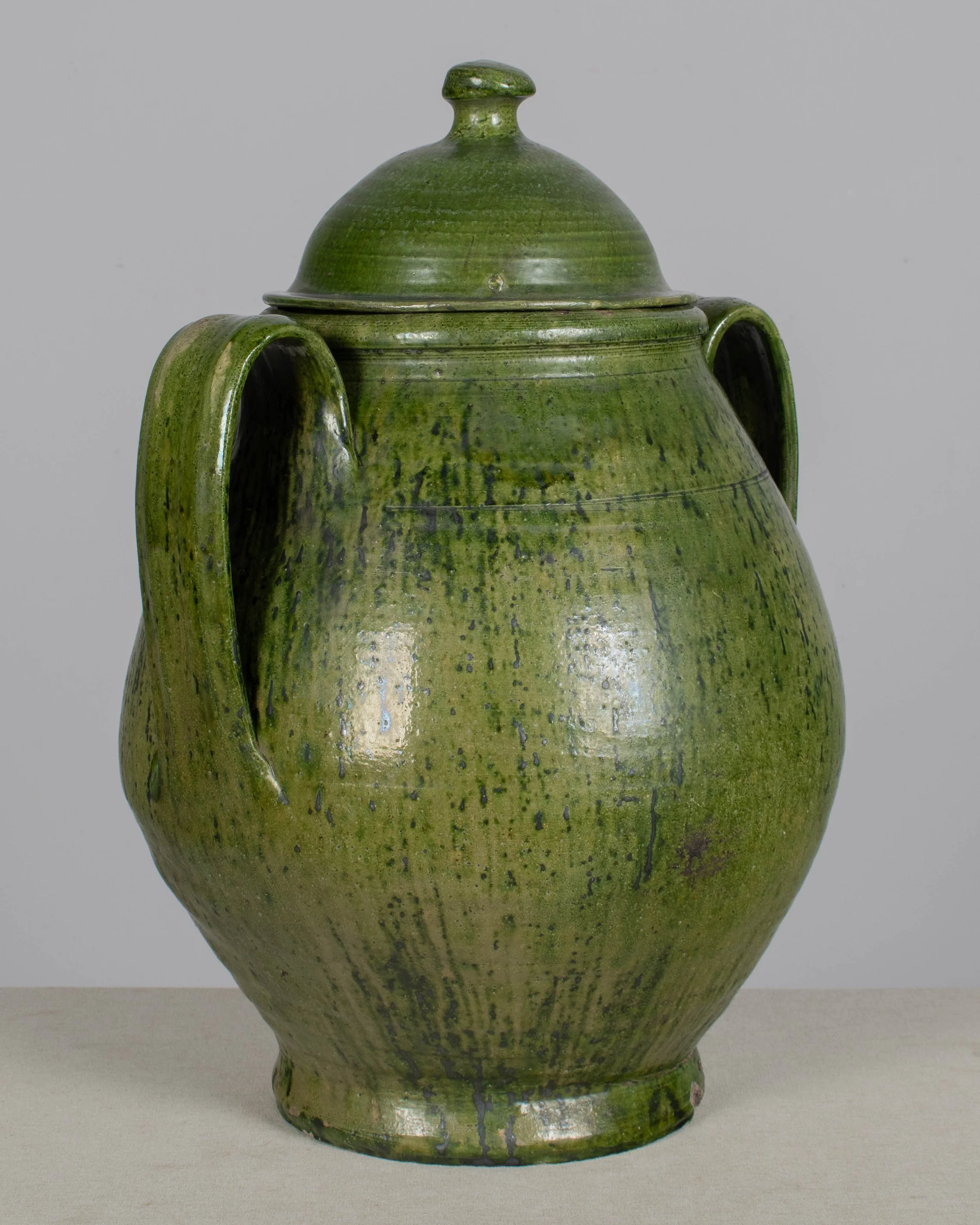 A large green glazed earthenware lidded jar made in Portugal