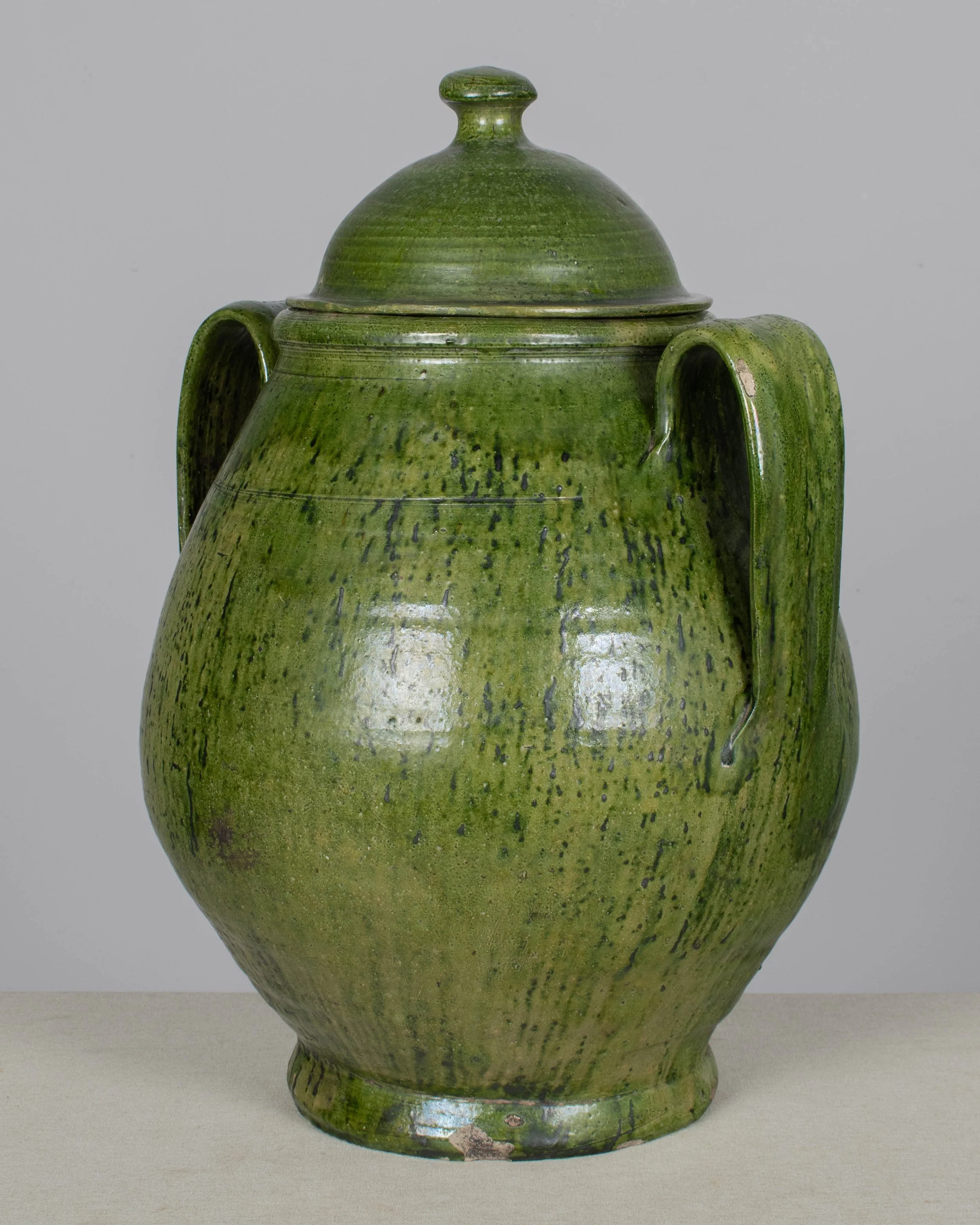 A large green glazed earthenware lidded jar made in Portugal