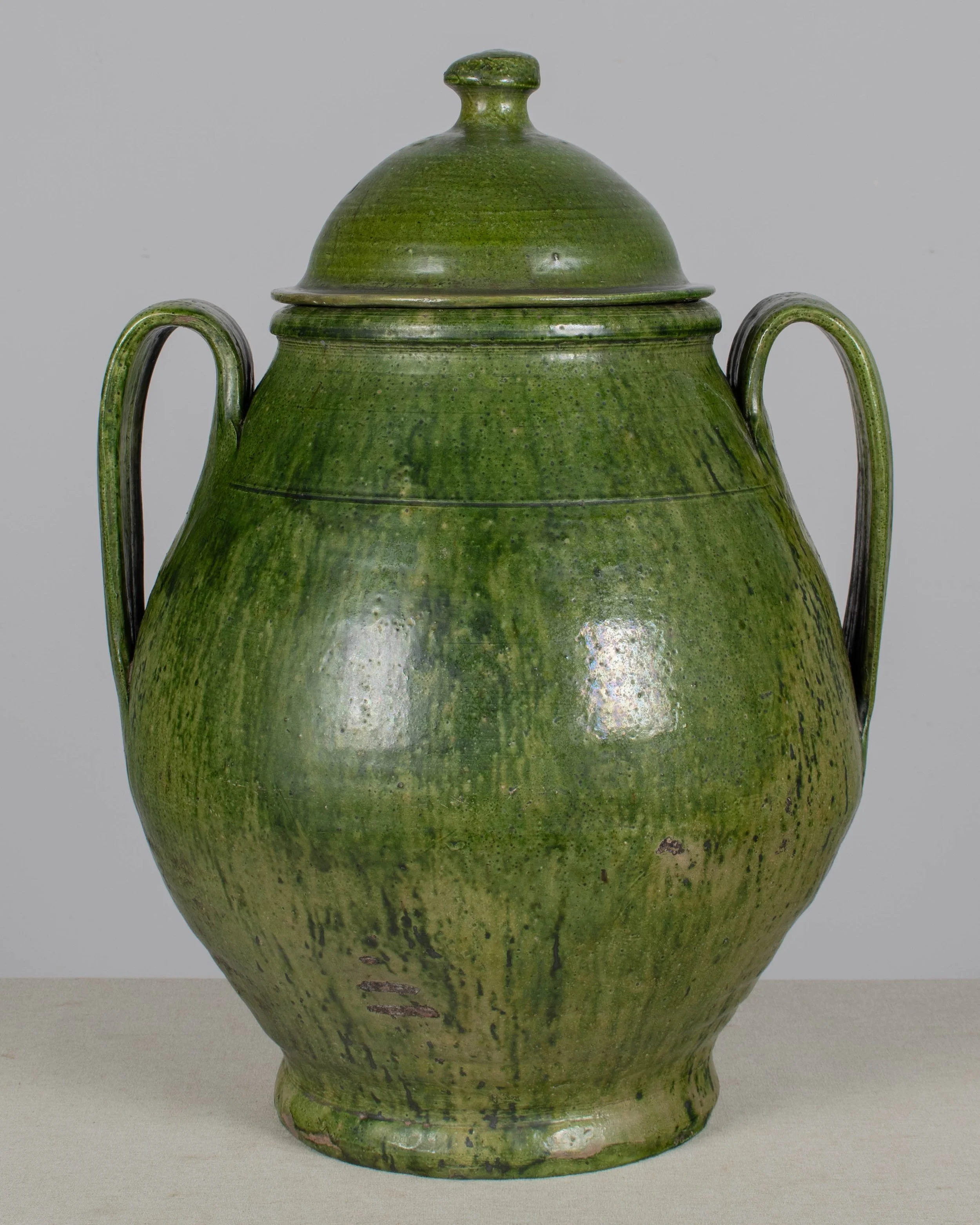 A large green glazed earthenware lidded jar made in Portugal
