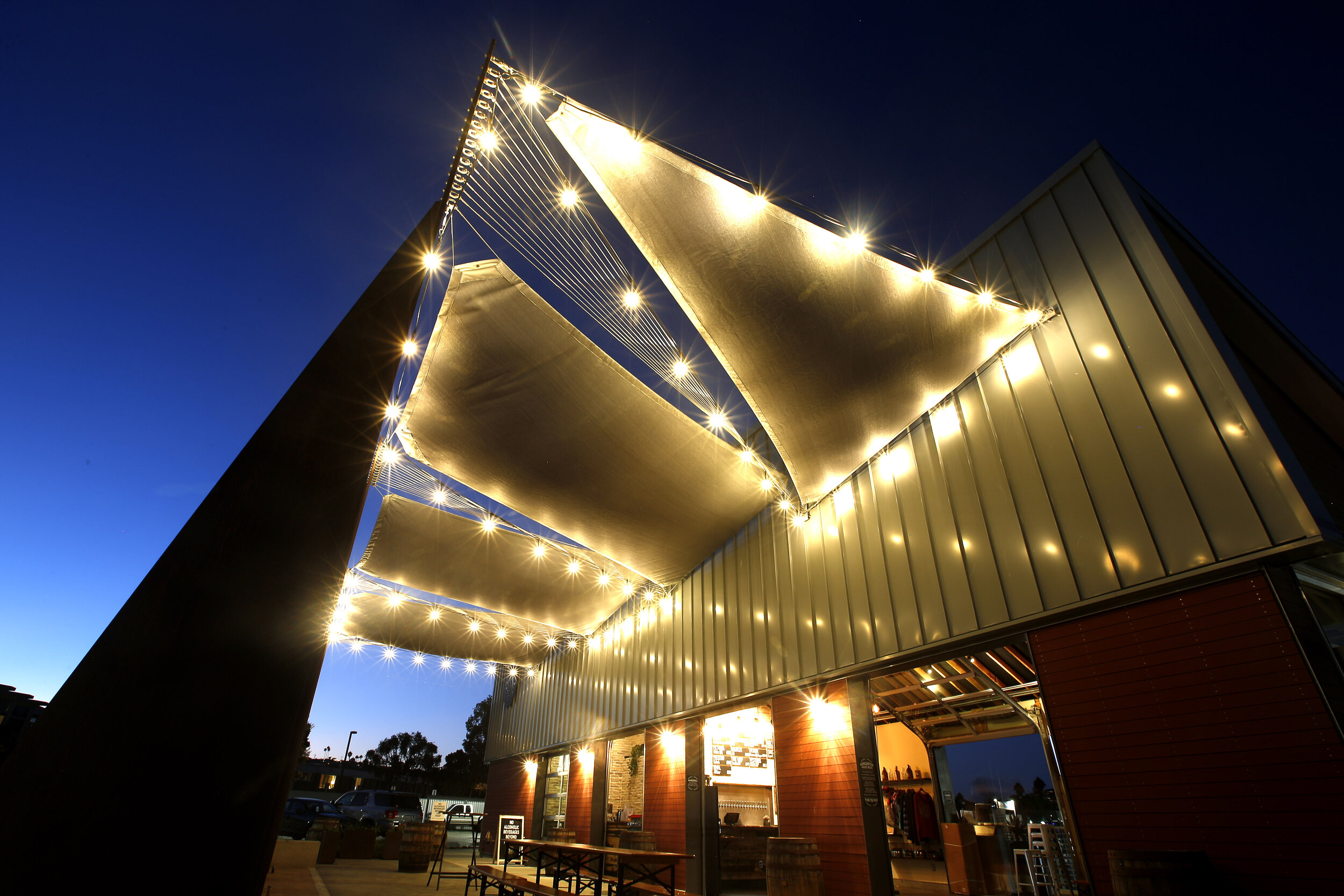 Nighttime image of illuminated building shade sails