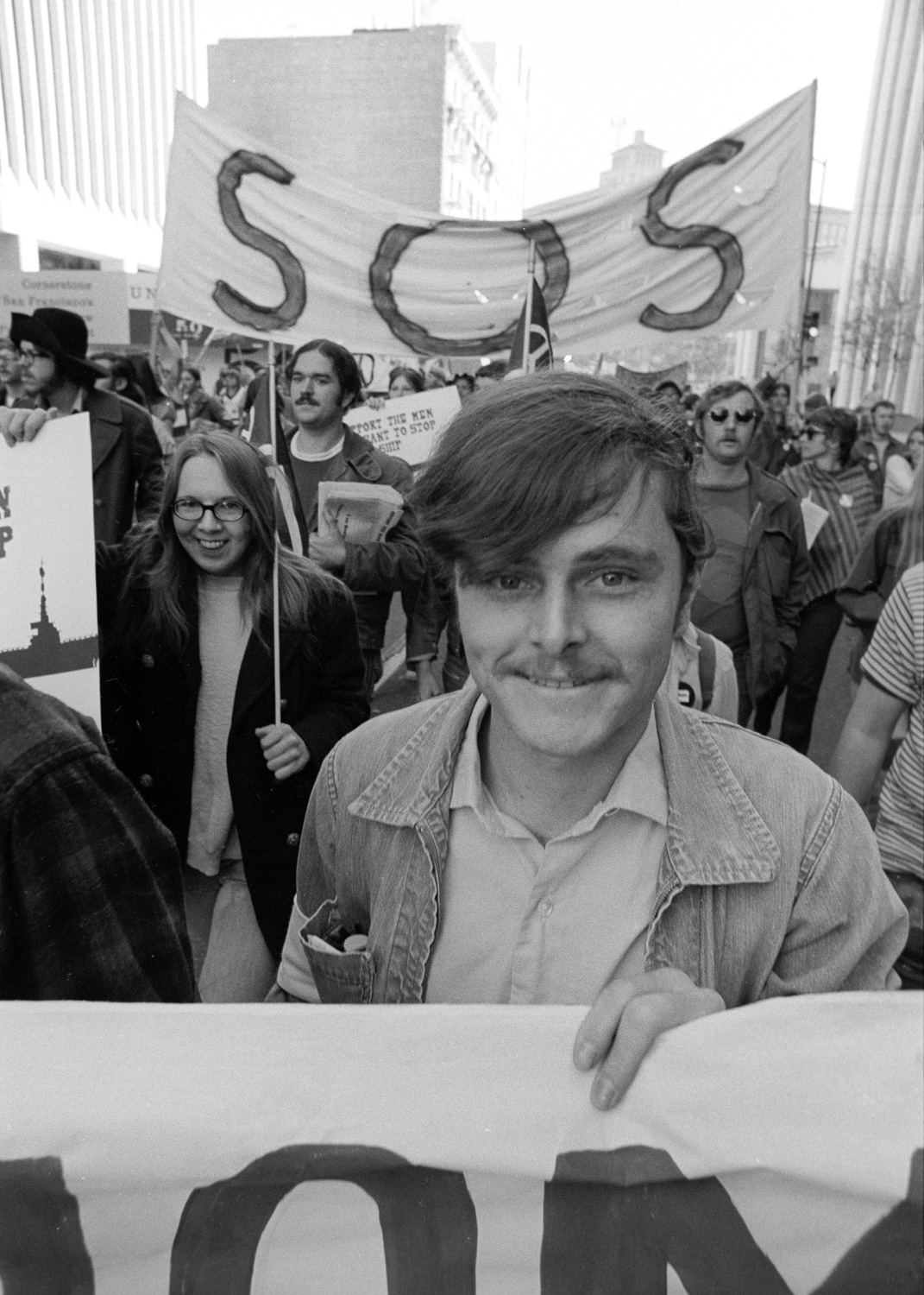 This sailor is happy to be marching with the Stop Our Ship group from the USS Coral Sea. This contingent led this anti-war march down Market Street on November 6, 1971.