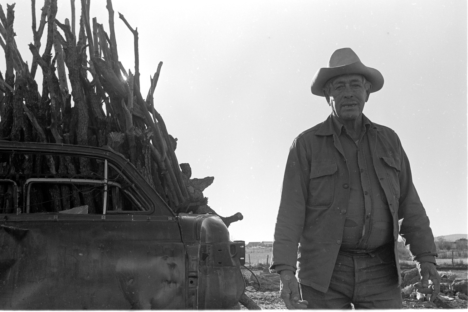  This farmer's face is as weather-beaten as the car door leaning against the stack of firewood. 