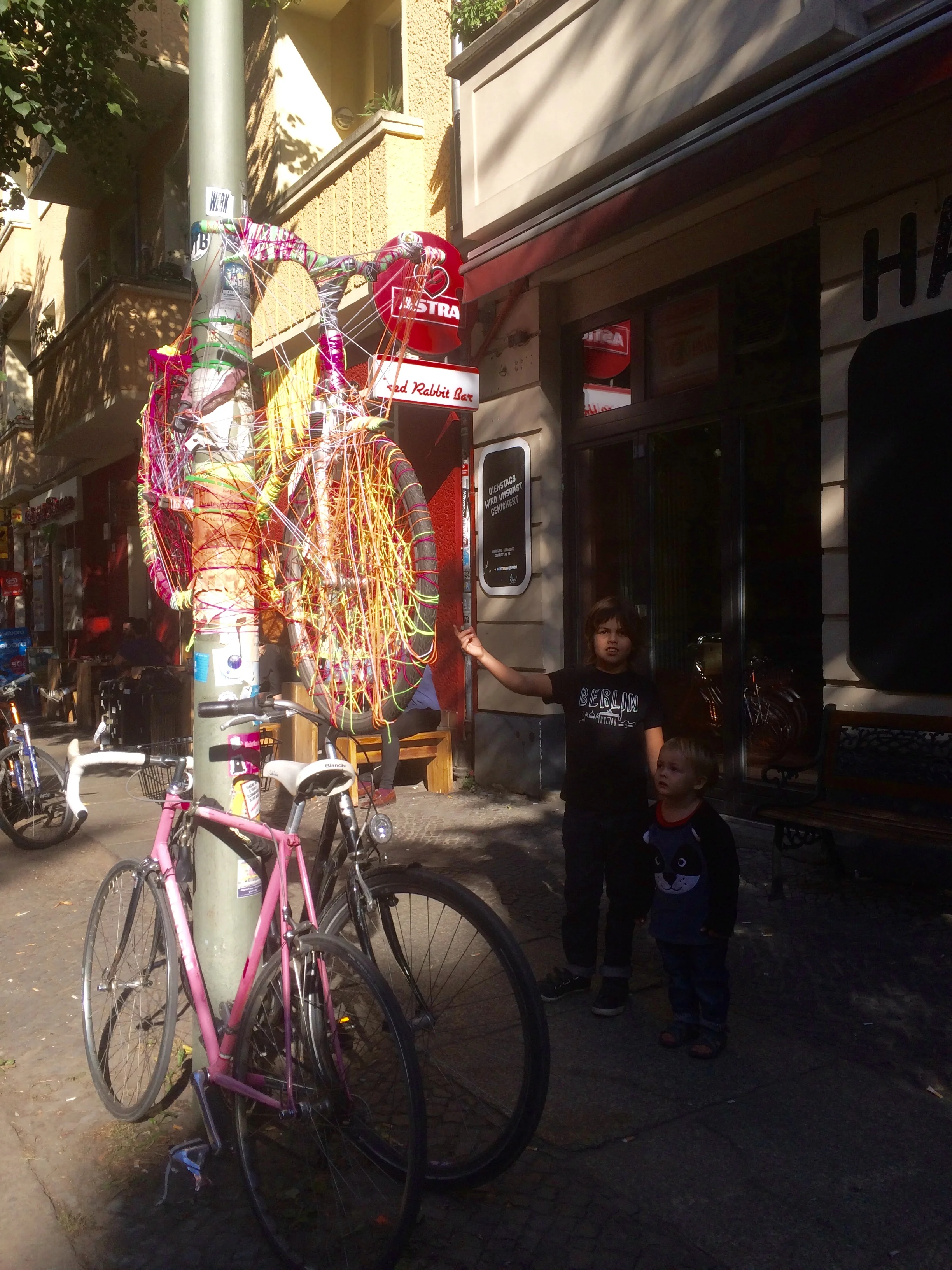 When we went to this shop, to send off a letter I wrote to my class. We posted the letter. When we got out we founds this bicycle hanging up. It was knitted onto the light pole. It looks really colourful and cool.
