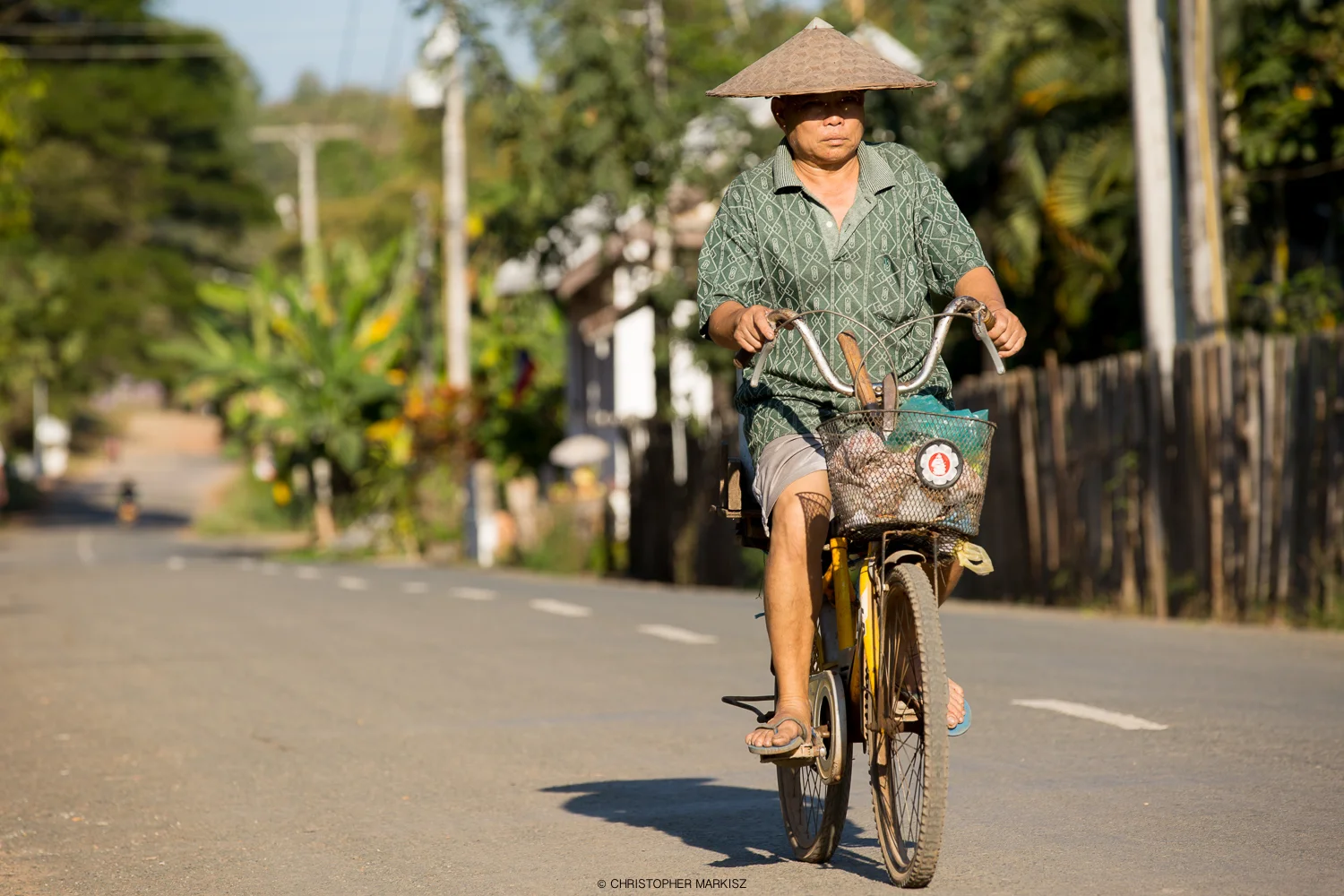 A villager rides a bicycle on a hot day in Luang Prabang, Laos.