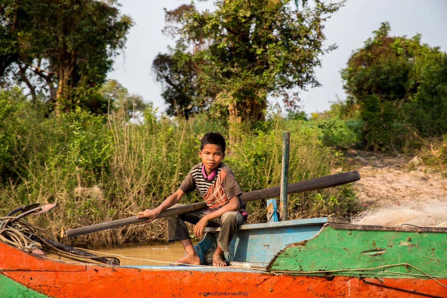 A boy sits on a boat in Kampong Phluk, a small Cambodia village on the Tonle Sap Lake, the largest freshwater lake in Southeast Asia.