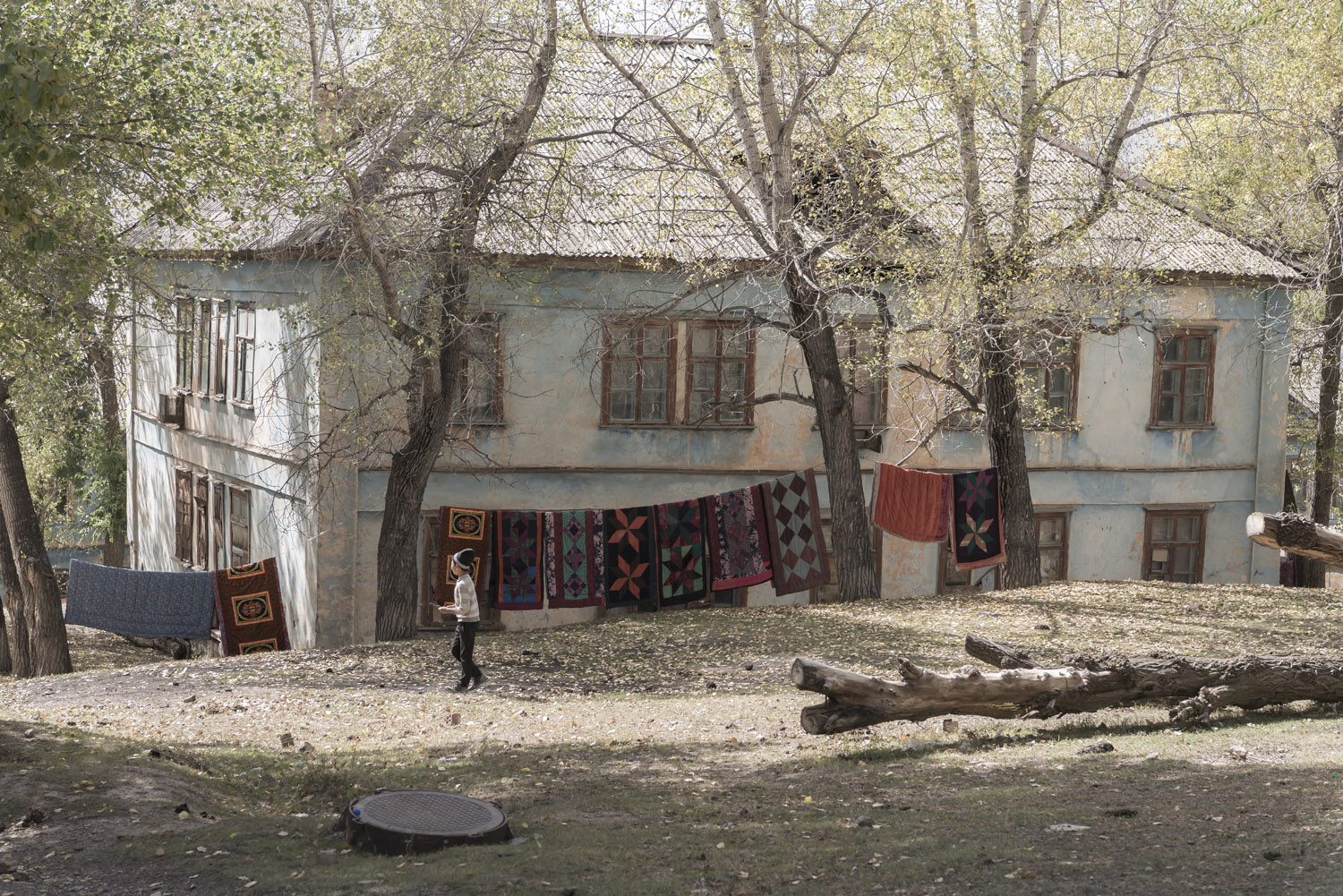 min-kush-soviet-uranium-mining-town-industrial-Russia-Kyrgyzstan-ruins-soviet-sign-jo-kearney-photos-video-photography-child-washing-blankets-drying.jpg