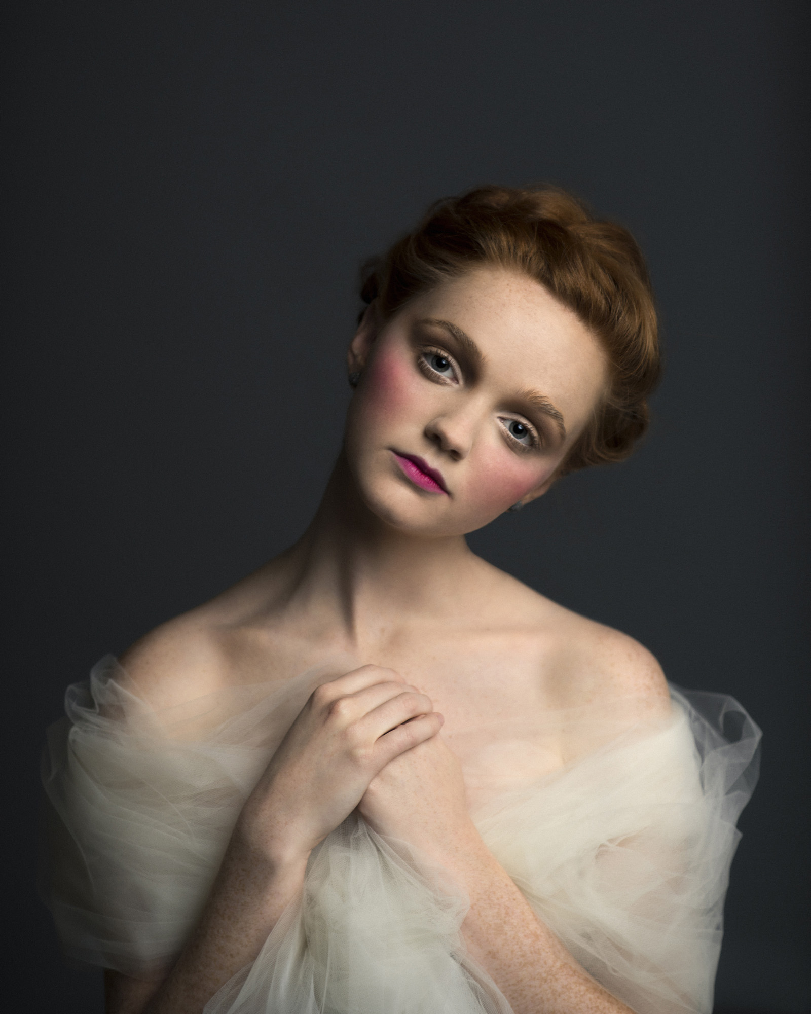 Romantic Victorian inspired studio portrait of a redhead model in tulle. By Sarah Hooker Photography