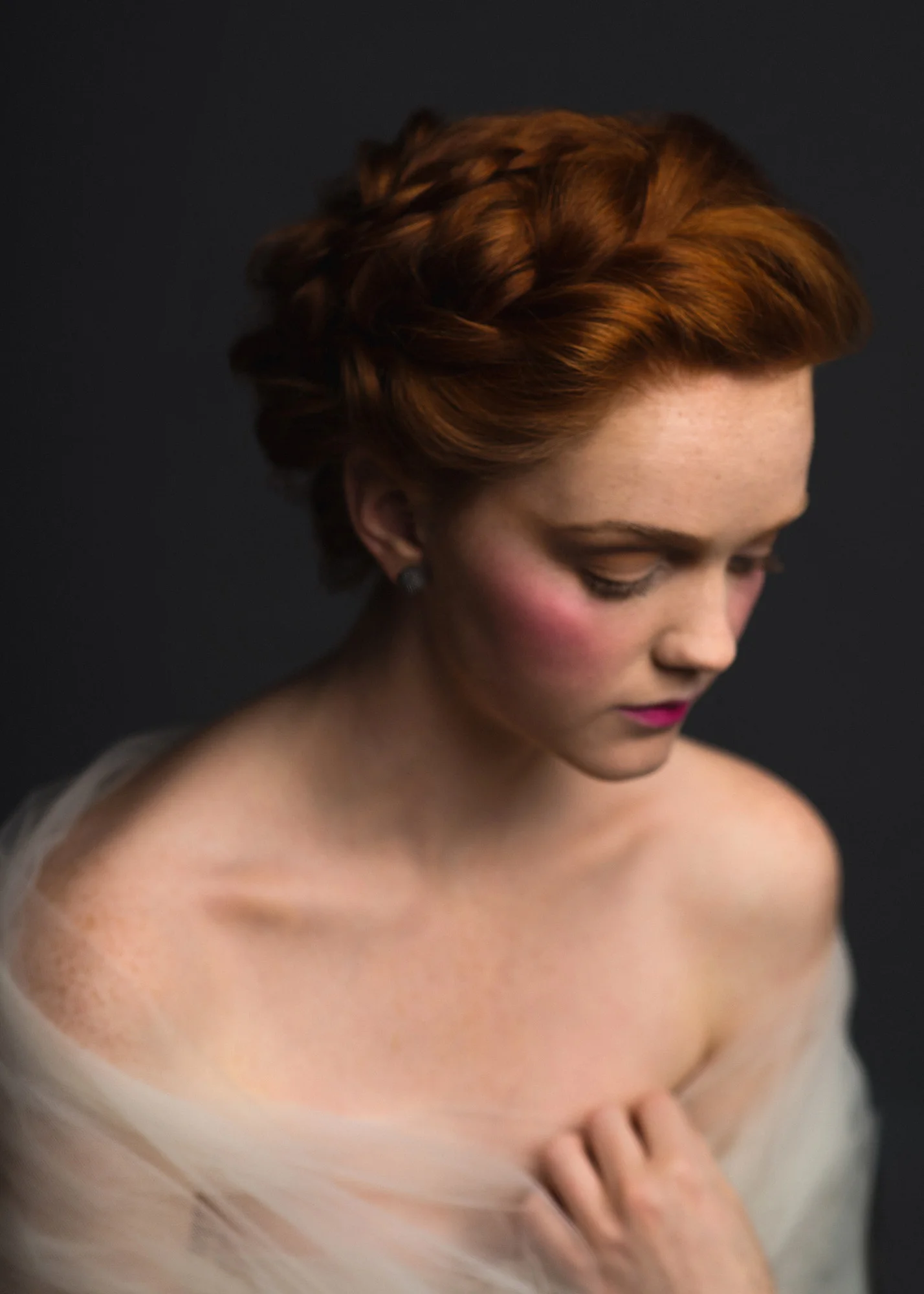 Romantic Victorian inspired studio portrait of a model wrapped in tulle with braided red hair. By Sarah Hooker Photography