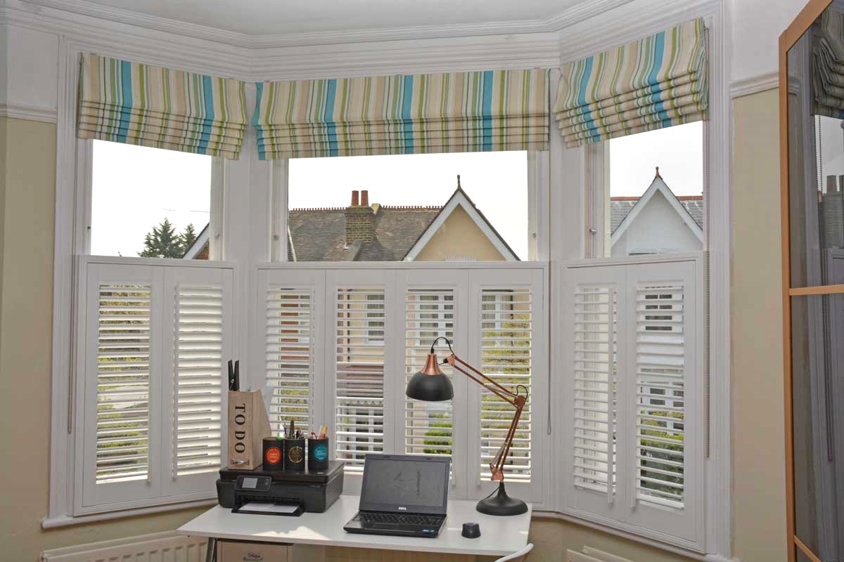 Roman blind with vertical striped fabric in a teal colour palette