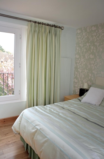 Full-length curtains with a shimmery, pale green fabric