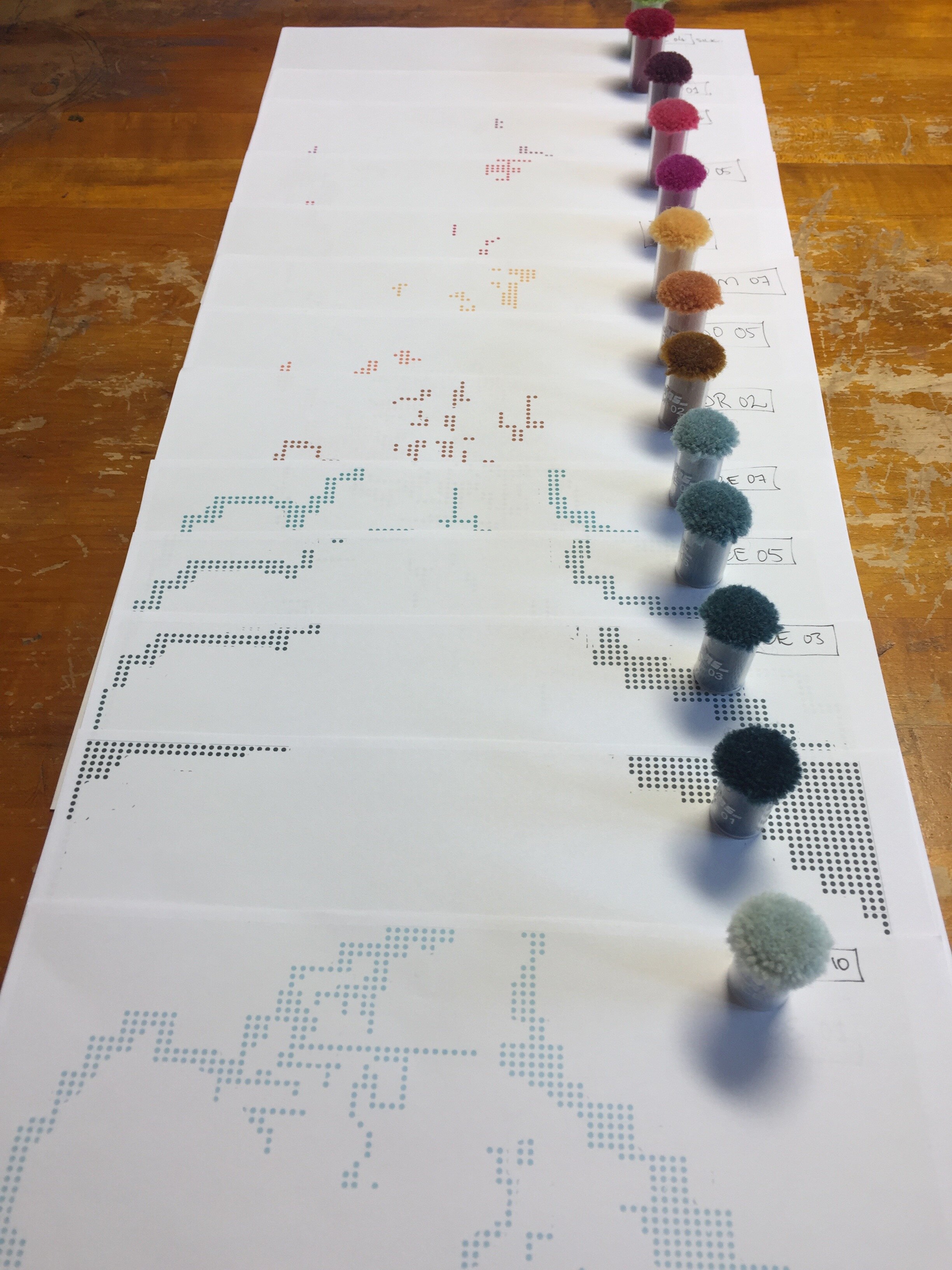  Selecting the carpet pom colours and organizing the sections of the Canada map for the “Oh Canada” Pom Mosaic™.  