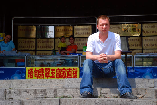 Sitting on the steps in front of an antique market at some old palace or other.