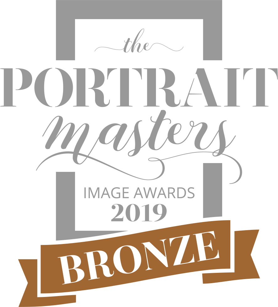 Bronze award badge with a brown ribbon and white text on a black background.