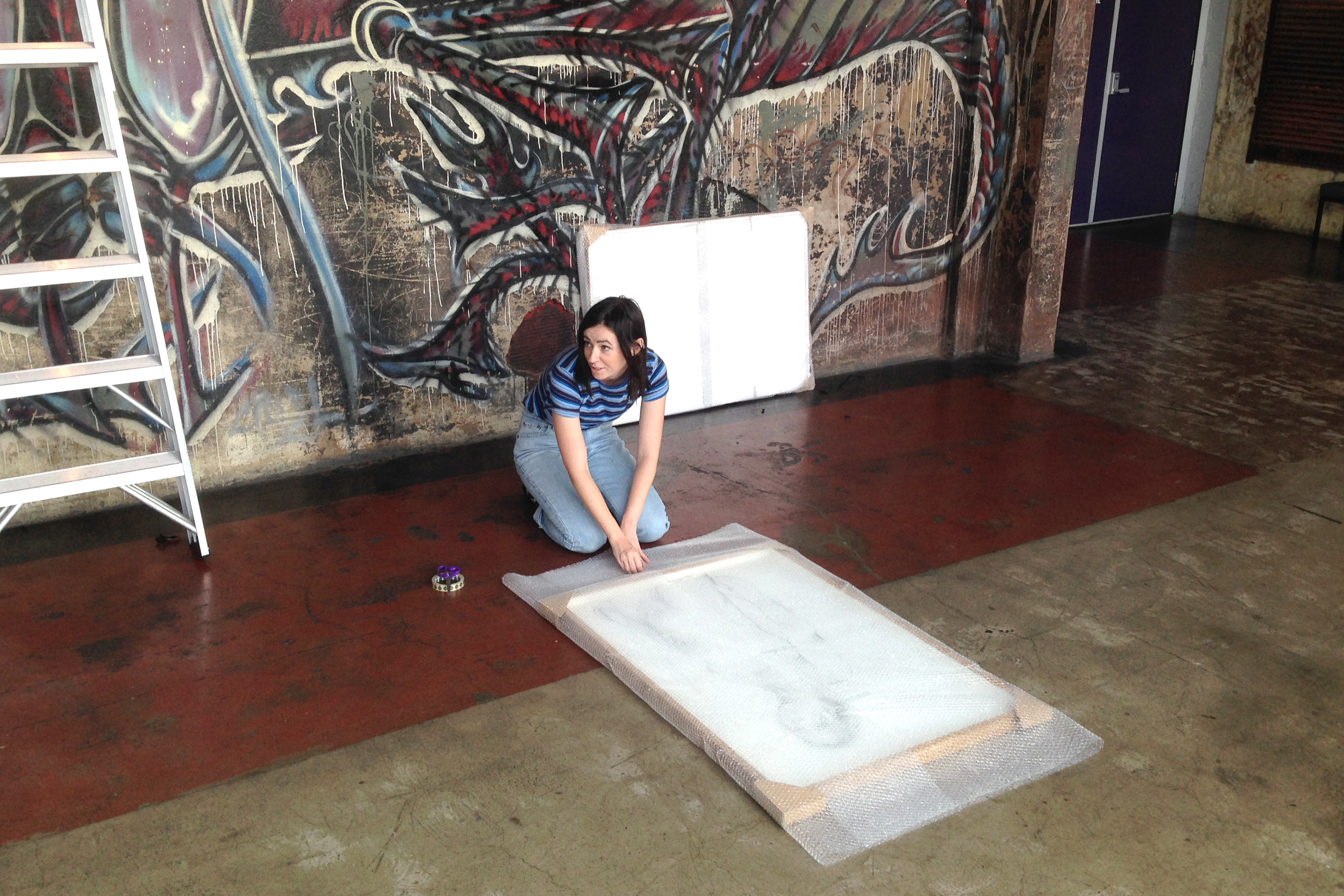 Alexandra Winters packing up an exhibition by Tyza at Brisbane Powerhouse.