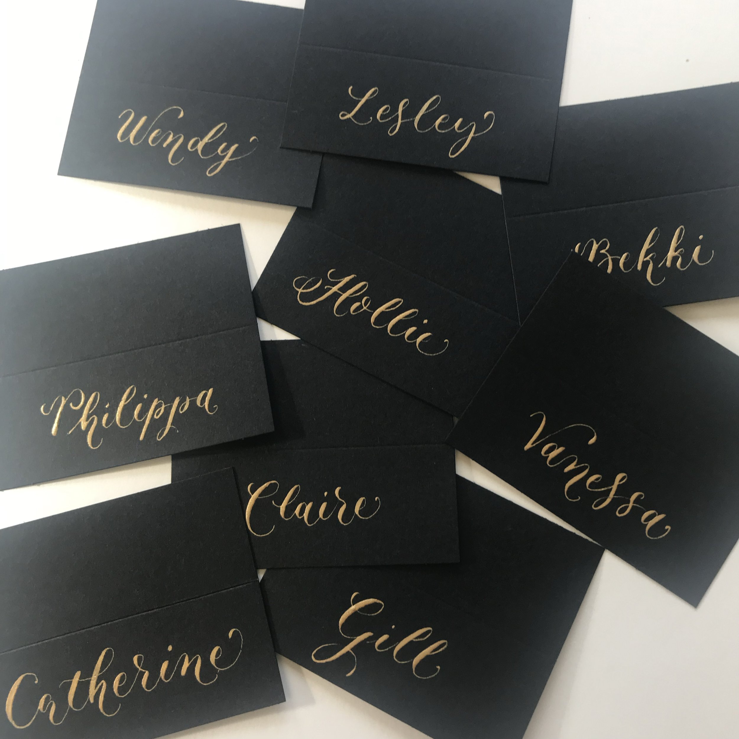 Gold calligraphy on black place cards.jpg