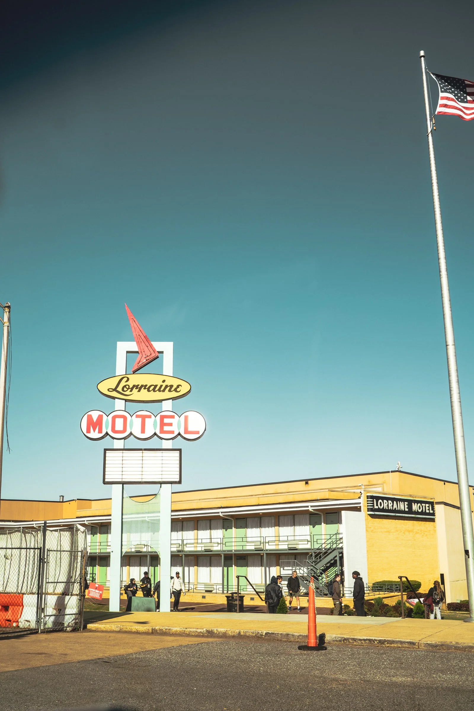 Exterior view of Lorraine Motel, a historic site now serving as a museum, with a large sign and several people outside on a sunny day.