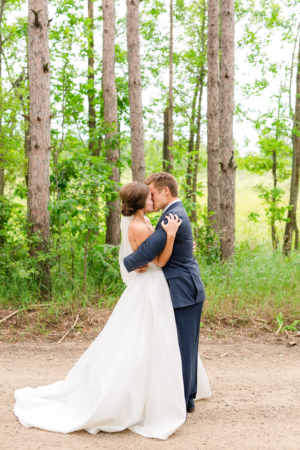 Wolf Lake, MN Country Styled Wedding, White Dress, Blue Suite | Photographed by Amber Langerud Photography | Bride and Groom Hugging after first look