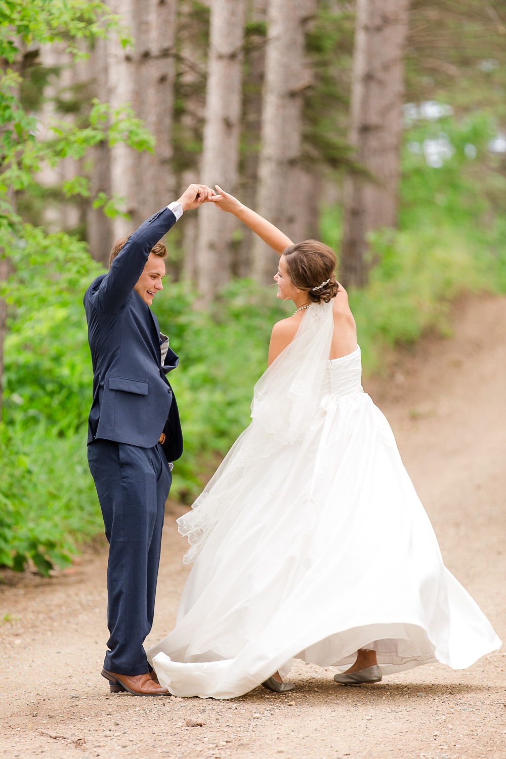 Wolf Lake, MN Country Styled Wedding, White Dress, Blue Suite | Photographed by Amber Langerud Photography | Close-up of Groom Twirling the Bride