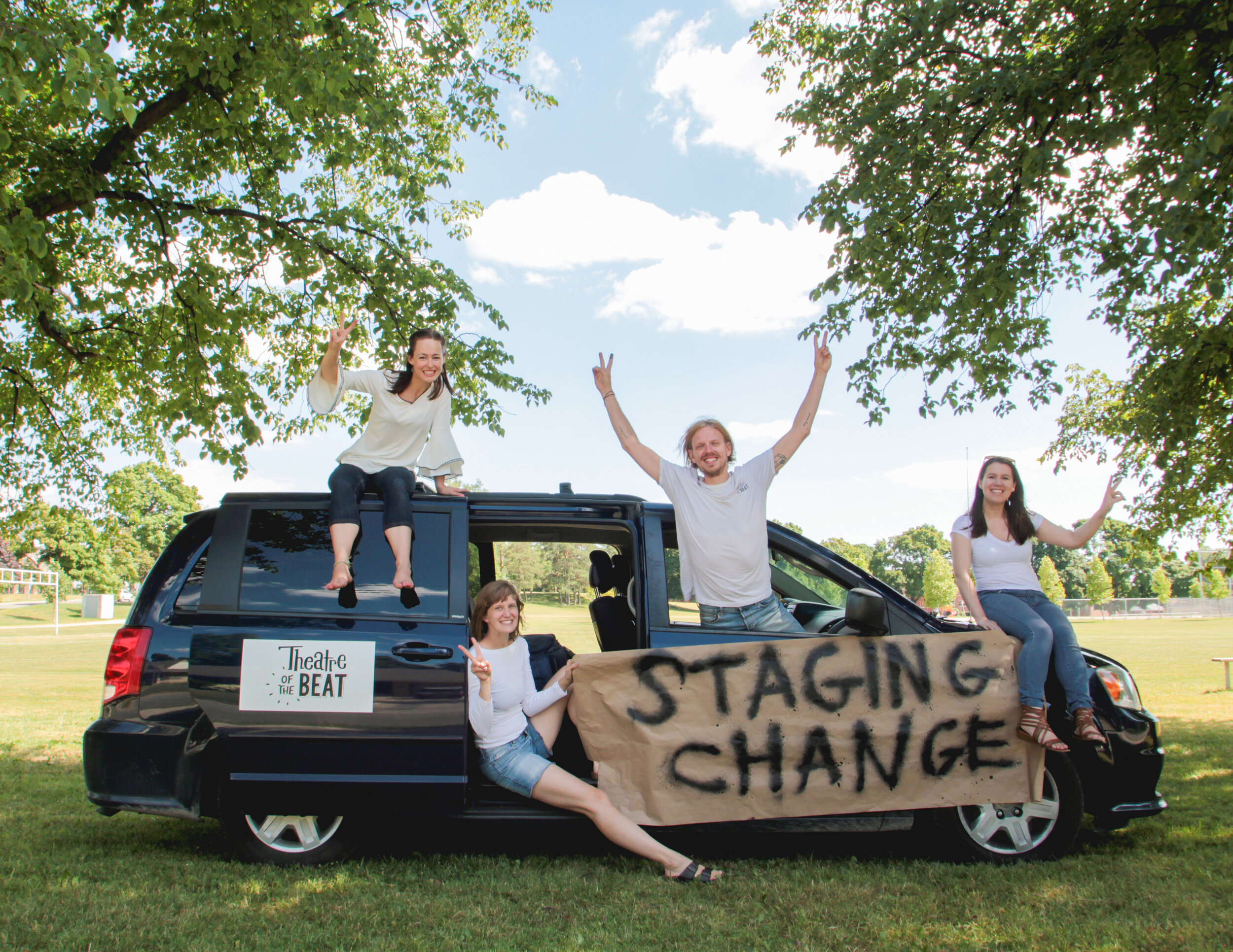  Kimberlee Walker, Rebecca Steiner, Johnny Wideman, and Laura McCallum in front of the Theatre of the Beat Tour Van holding a sign saying “STAGINING CHANGE” 