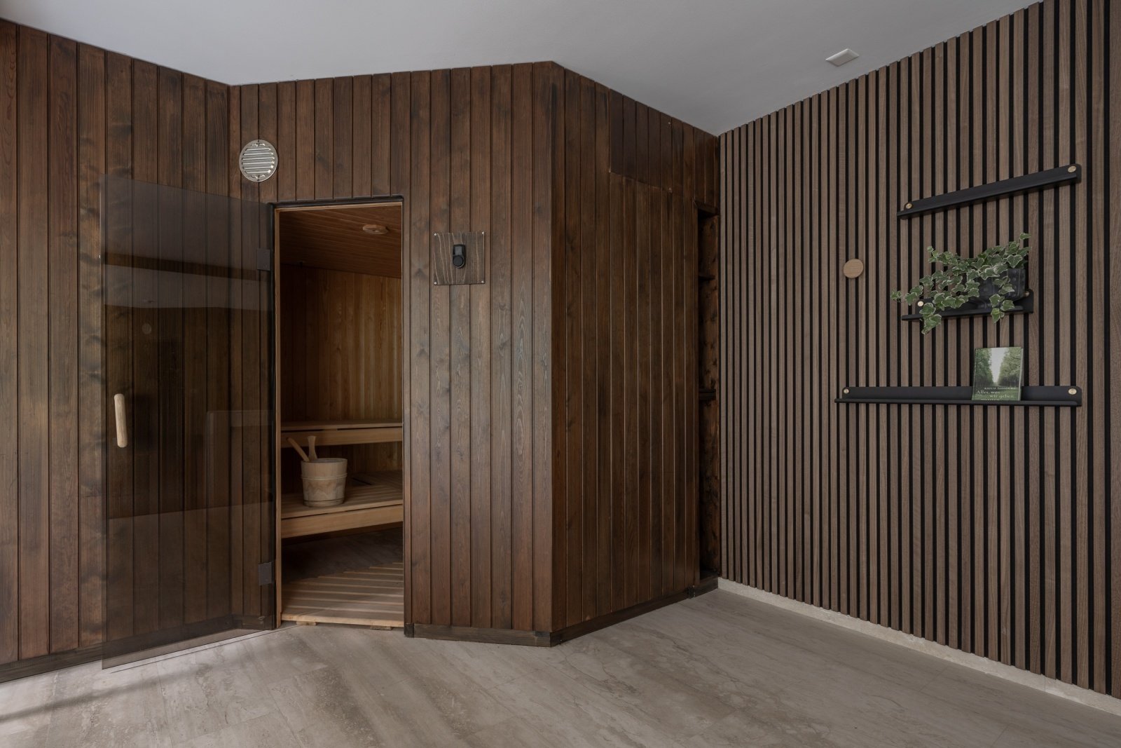 Sauna and wellness area with dark wood cladding at Landhaus Ennetmoos.