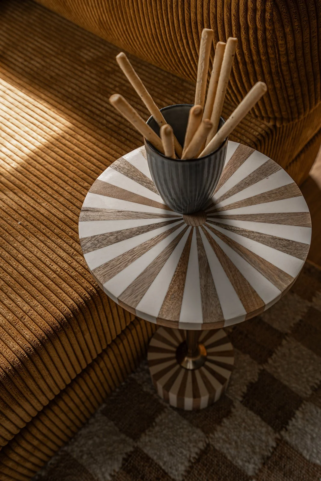 Decorative side table beside the corduroy sofa in the home cinema.