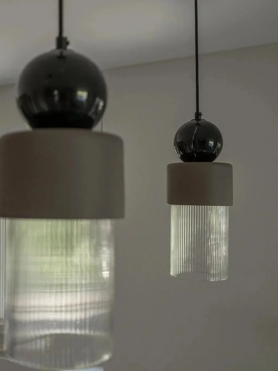 Detail of sculptural pendant lights combining marble, ceramic and ribbed glass.