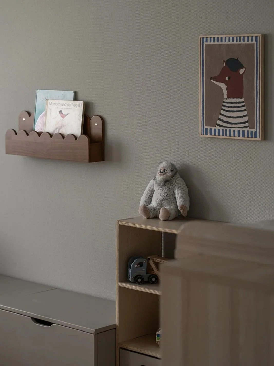 Kids’ room reading corner with wall-mounted book storage and plywood furniture at Landhaus Ennetmoos.