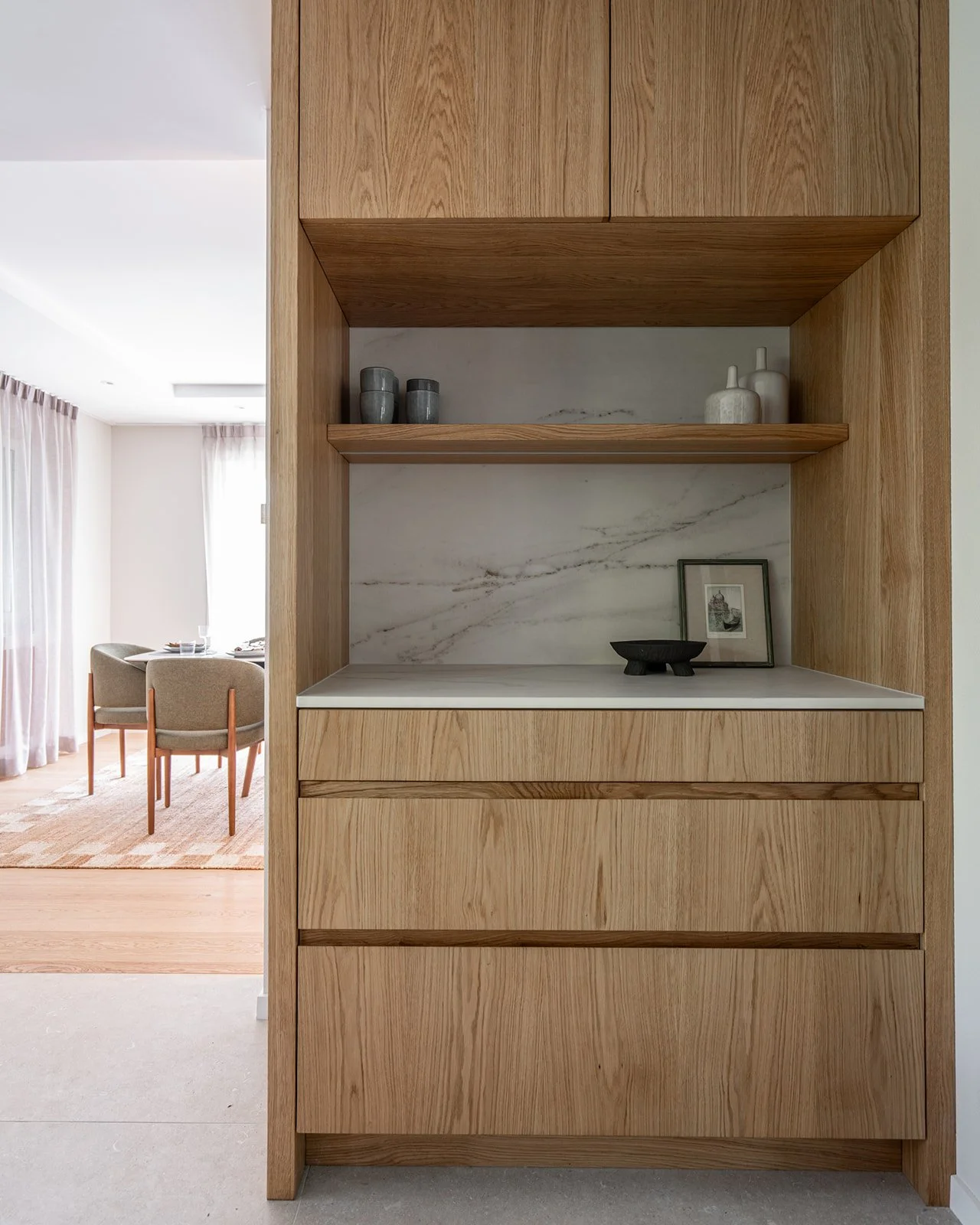 Bespoke oak coffee corner with open shelving, stone backsplash and dedicated space for everyday essentials.