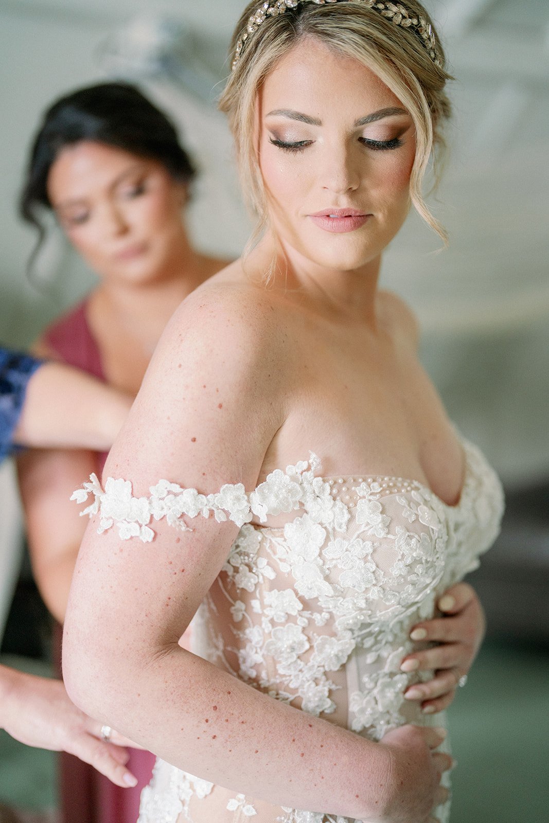 Bride getting dressed in strapless wedding dress