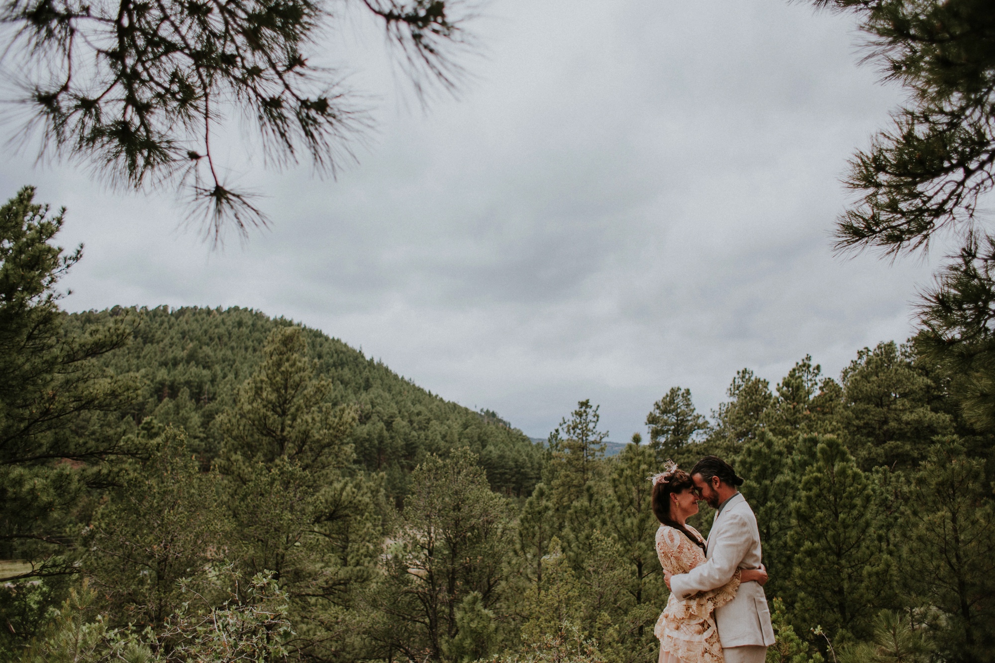  The dress theme for the whole wedding celebration was rainbows - their guests dressed in one color head to toe as part of the theme. The wedding reception at the ranch was near the orchard by the acequia, and was lit by candles and solar lights prim