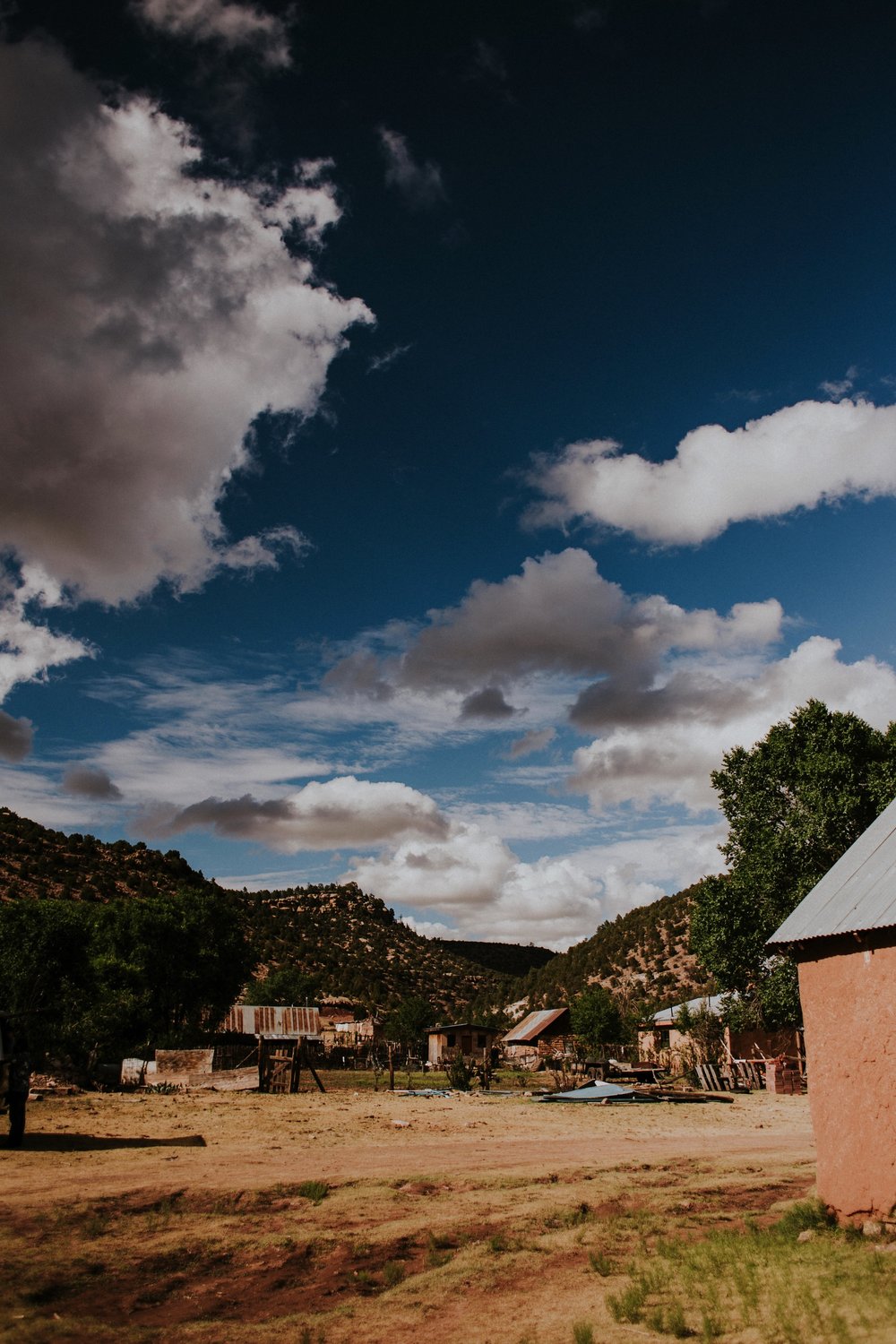  The dress theme for the whole wedding celebration was rainbows - their guests dressed in one color head to toe as part of the theme. The wedding reception at the ranch was near the orchard by the acequia, and was lit by candles and solar lights prim