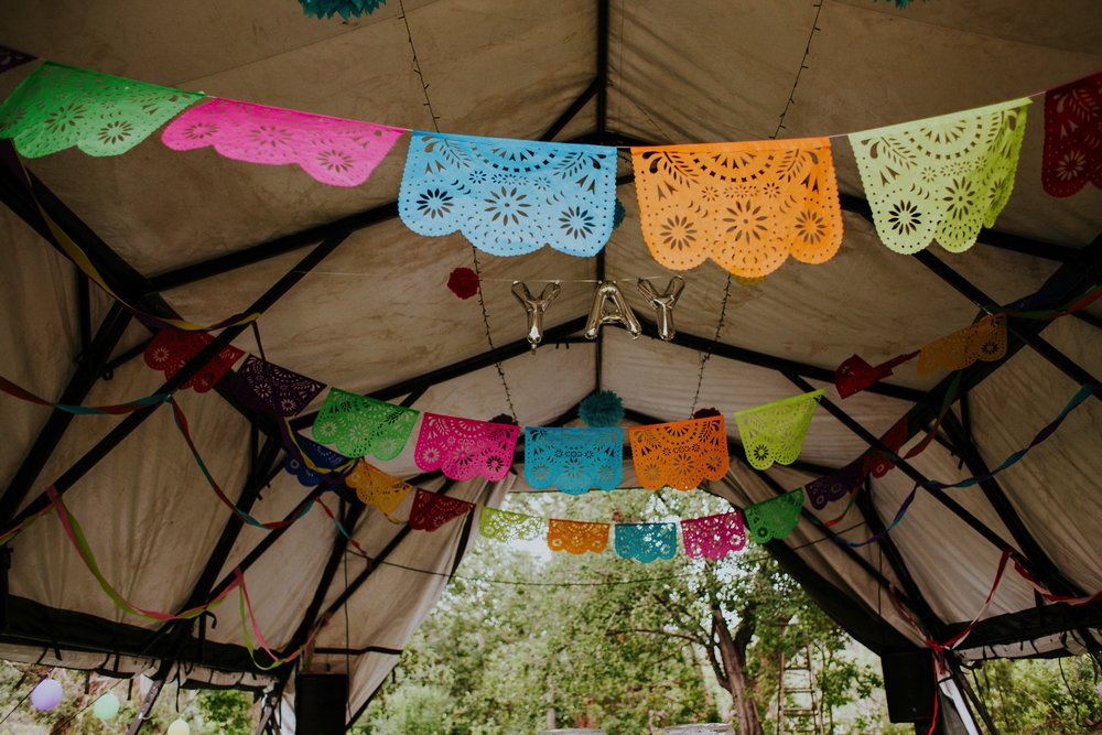  The dress theme for the whole wedding celebration was rainbows - their guests dressed in one color head to toe as part of the theme. The wedding reception at the ranch was near the orchard by the acequia, and was lit by candles and solar lights prim