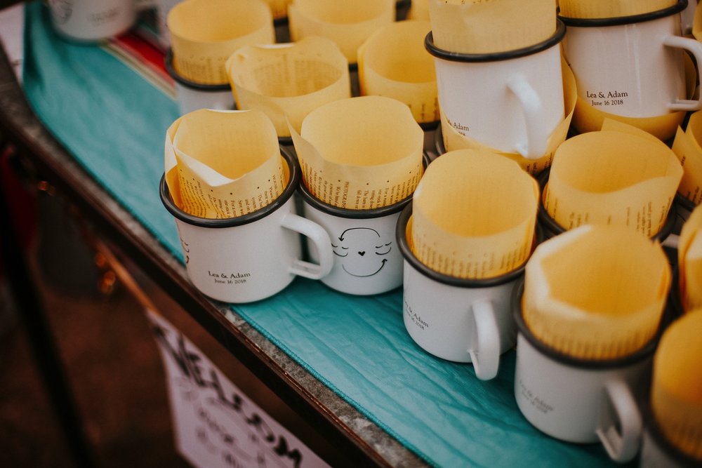  They arrived by rainbow procession from the river to their gorgeous wedding reception. They made cups for everyone with an image from a note one of them left for the other early in their relationship that has become a note that they leave often for 