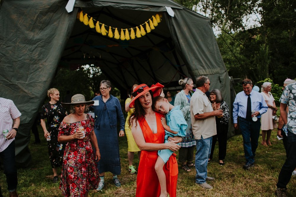  The dress theme for the whole wedding celebration was rainbows - their guests dressed in one color head to toe as part of the theme. The wedding reception at the ranch was near the orchard by the acequia, and was lit by candles and solar lights prim