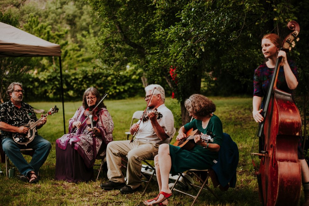  The dress theme for the whole wedding celebration was rainbows - their guests dressed in one color head to toe as part of the theme. The wedding reception at the ranch was near the orchard by the acequia, and was lit by candles and solar lights prim