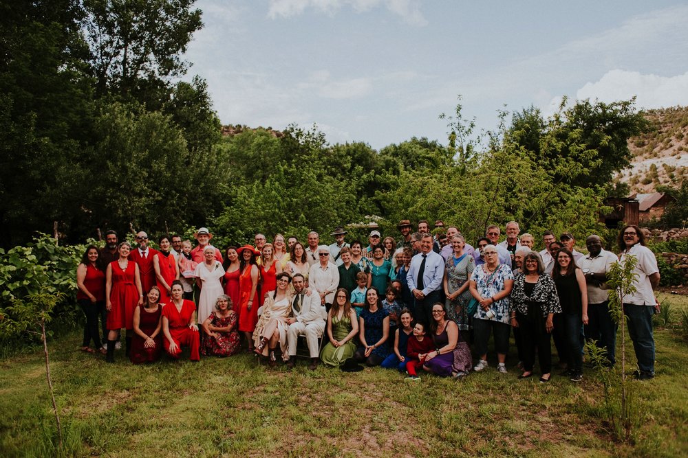  The dress theme for the whole wedding celebration was rainbows - their guests dressed in one color head to toe as part of the theme. The wedding reception at the ranch was near the orchard by the acequia, and was lit by candles and solar lights prim