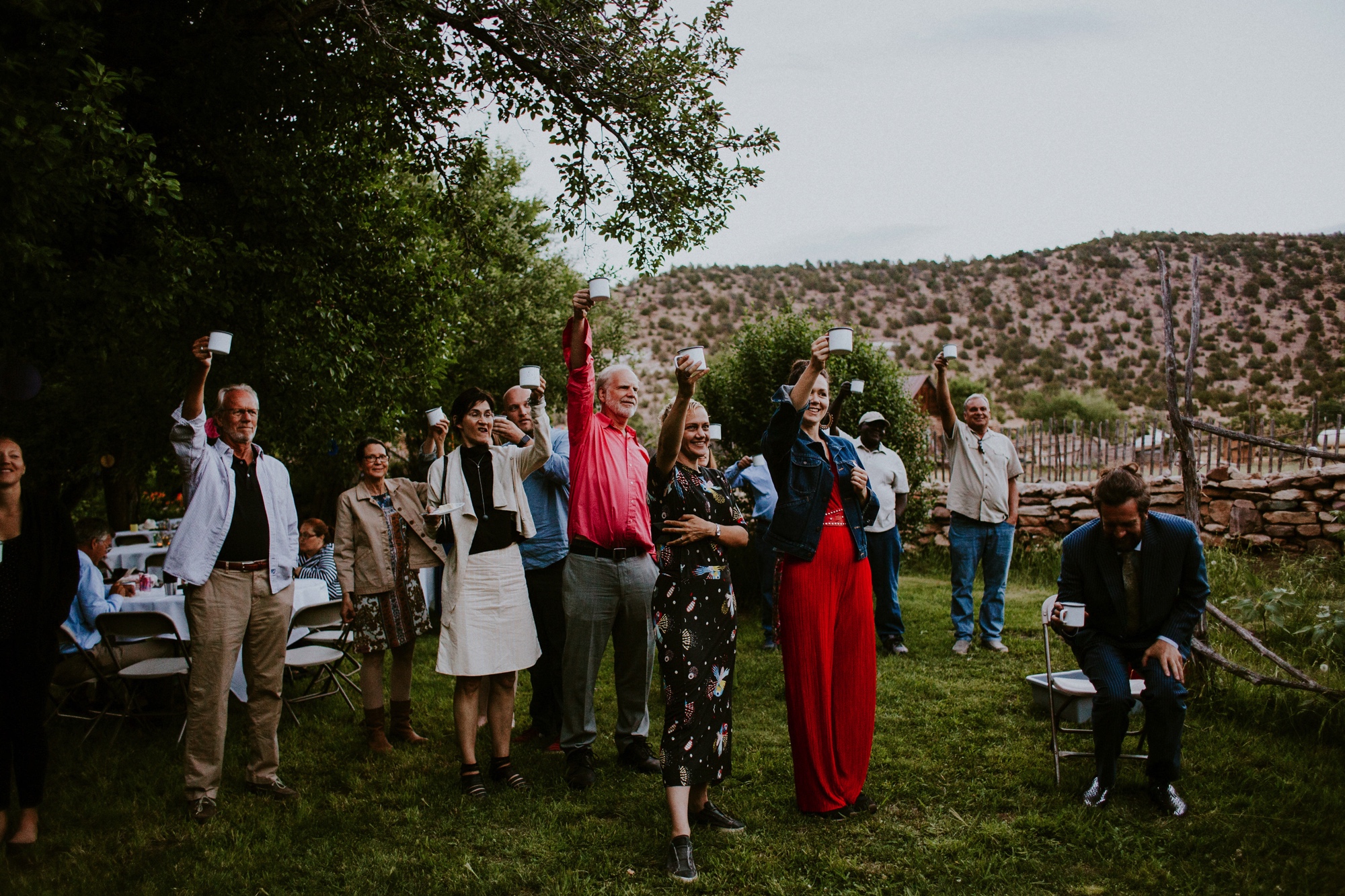  The dress theme for the whole wedding celebration was rainbows - their guests dressed in one color head to toe as part of the theme. The wedding reception at the ranch was near the orchard by the acequia, and was lit by candles and solar lights prim