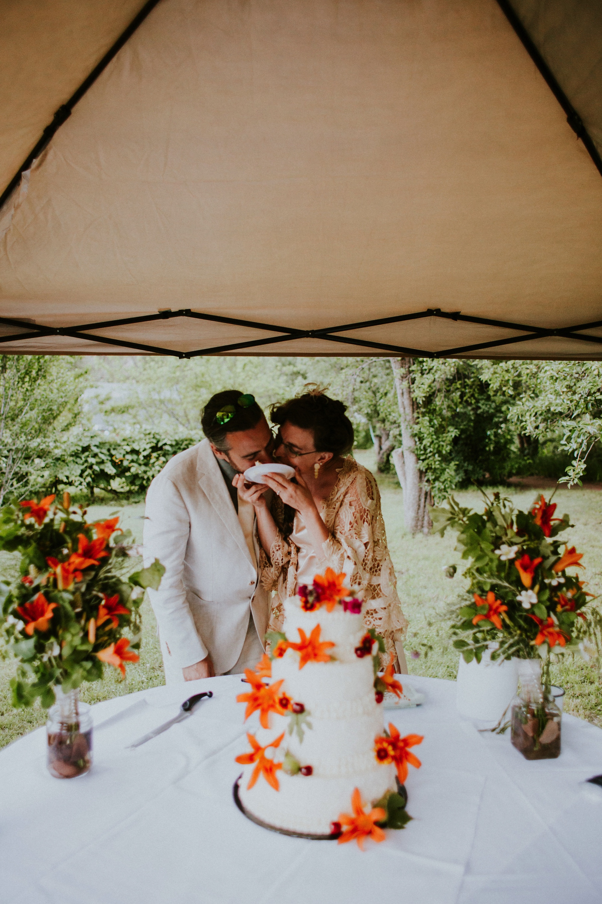  The dress theme for the whole wedding celebration was rainbows - their guests dressed in one color head to toe as part of the theme. The wedding reception at the ranch was near the orchard by the acequia, and was lit by candles and solar lights prim