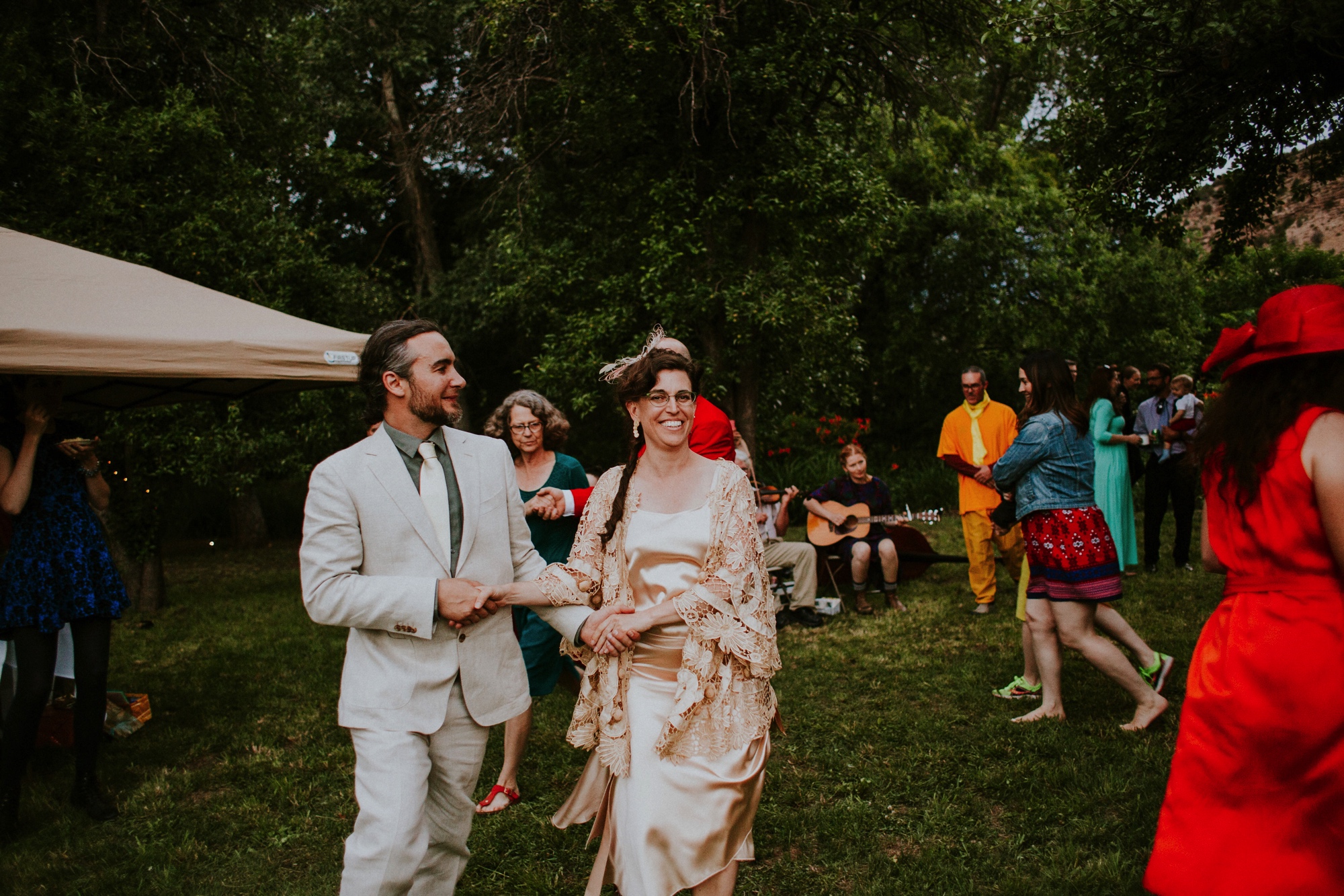  The dress theme for the whole wedding celebration was rainbows - their guests dressed in one color head to toe as part of the theme. The wedding reception at the ranch was near the orchard by the acequia, and was lit by candles and solar lights prim