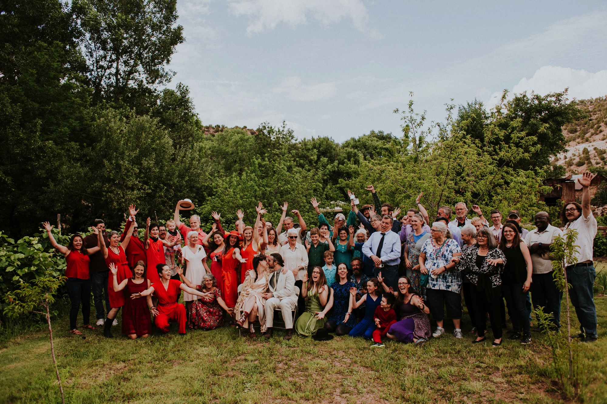  The dress theme for the whole wedding celebration was rainbows - their guests dressed in one color head to toe as part of the theme. The wedding reception at the ranch was near the orchard by the acequia, and was lit by candles and solar lights prim