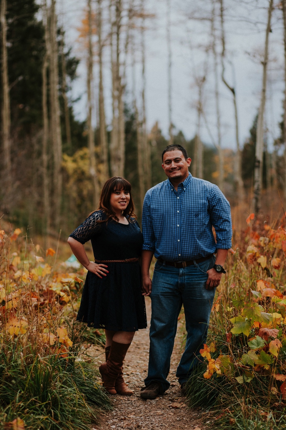  Suzie and Cruz chose the perfect fall engagement outfits for their Santa Fe engagement photos. You can never go wrong with cute brown boots and a blue lace dress! Cruz completed the rustic engagement look with a blue checkered button up and jeans. I