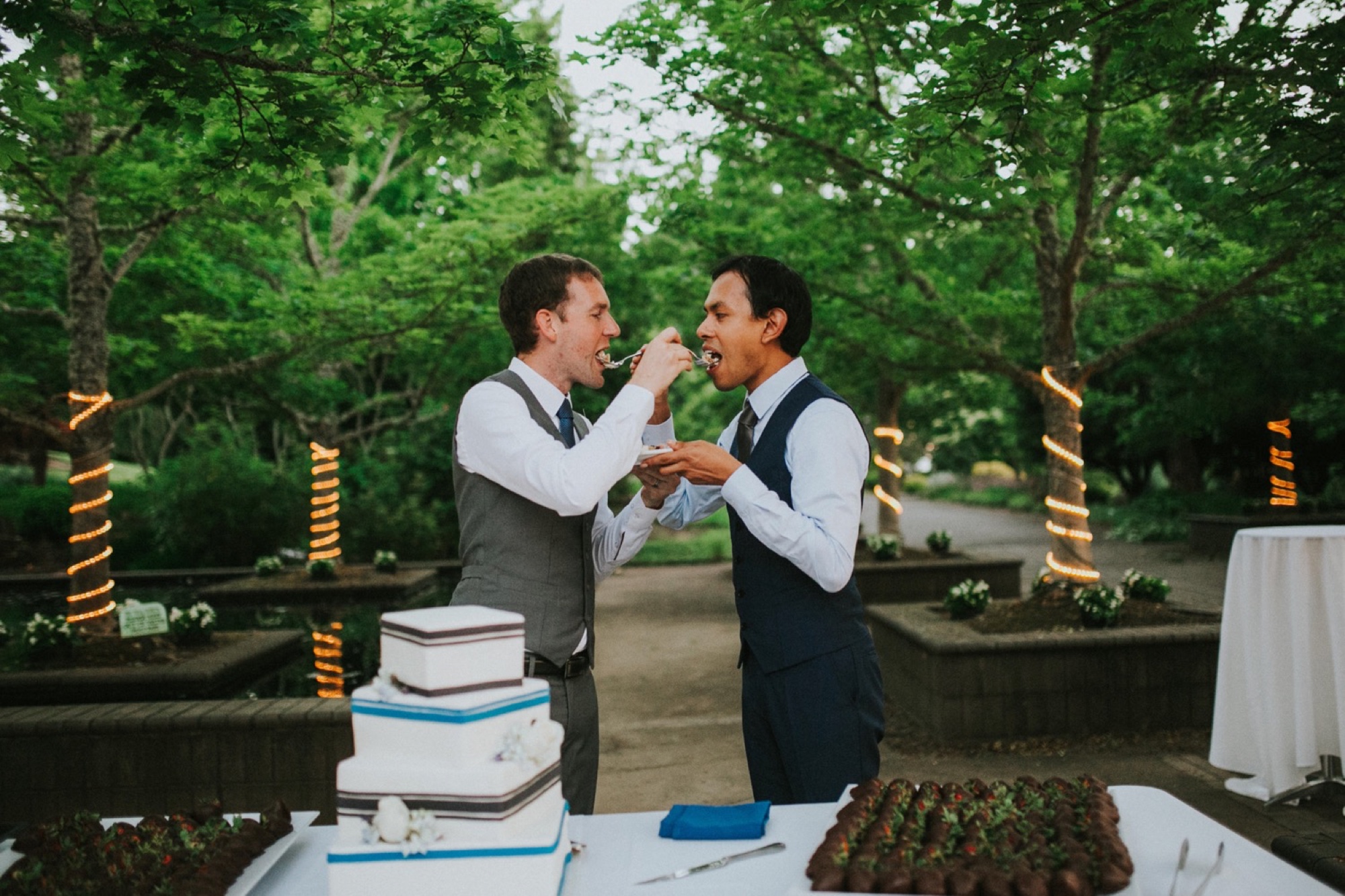 Daniel and Jeremy had a truly enchanting and magical wedding at The Oregon Garden Resort in Silverton, Oregon. It was truly beyond stunning from decor to scenery to each beautiful moment throughout the entire day. Along with the fabulous scenery including all of the greenery and fresh florals in bloom, the decor and theme Daniel and Jeremy chose for their special day was seriously SO COOL. Daniel and Jeremy are both flight attendants so the theme for their big day was travel (and of course, airplanes!). The blue tones and travel themed decor was the perfect mix of elegance and quirk.