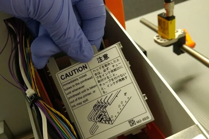16. We are now ready to remove the printhead and blade cleaner. It is recommended to have a paper towel or bin to place these objects after removal. Lift up on the handle marked "1" on the print module - reference the diagrams shown in the parts replacement utility for further reference
