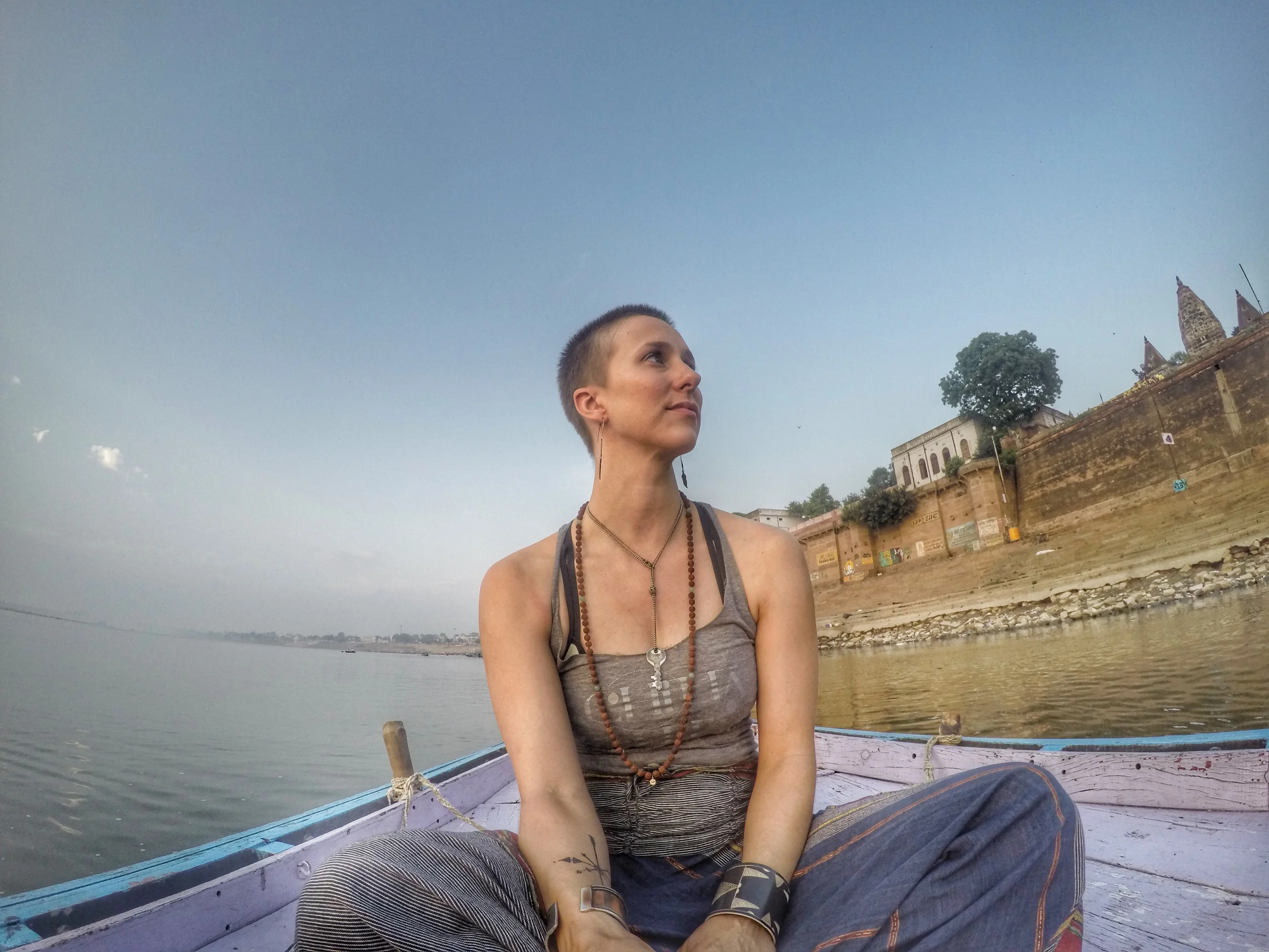 Megan floats on the Ganges in June, 2015, complete with a mala and building sense of awe.