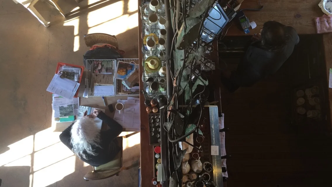 Fleur, sitting in her lovely Place, writing a message about strength to me in her book/Moeraki village.