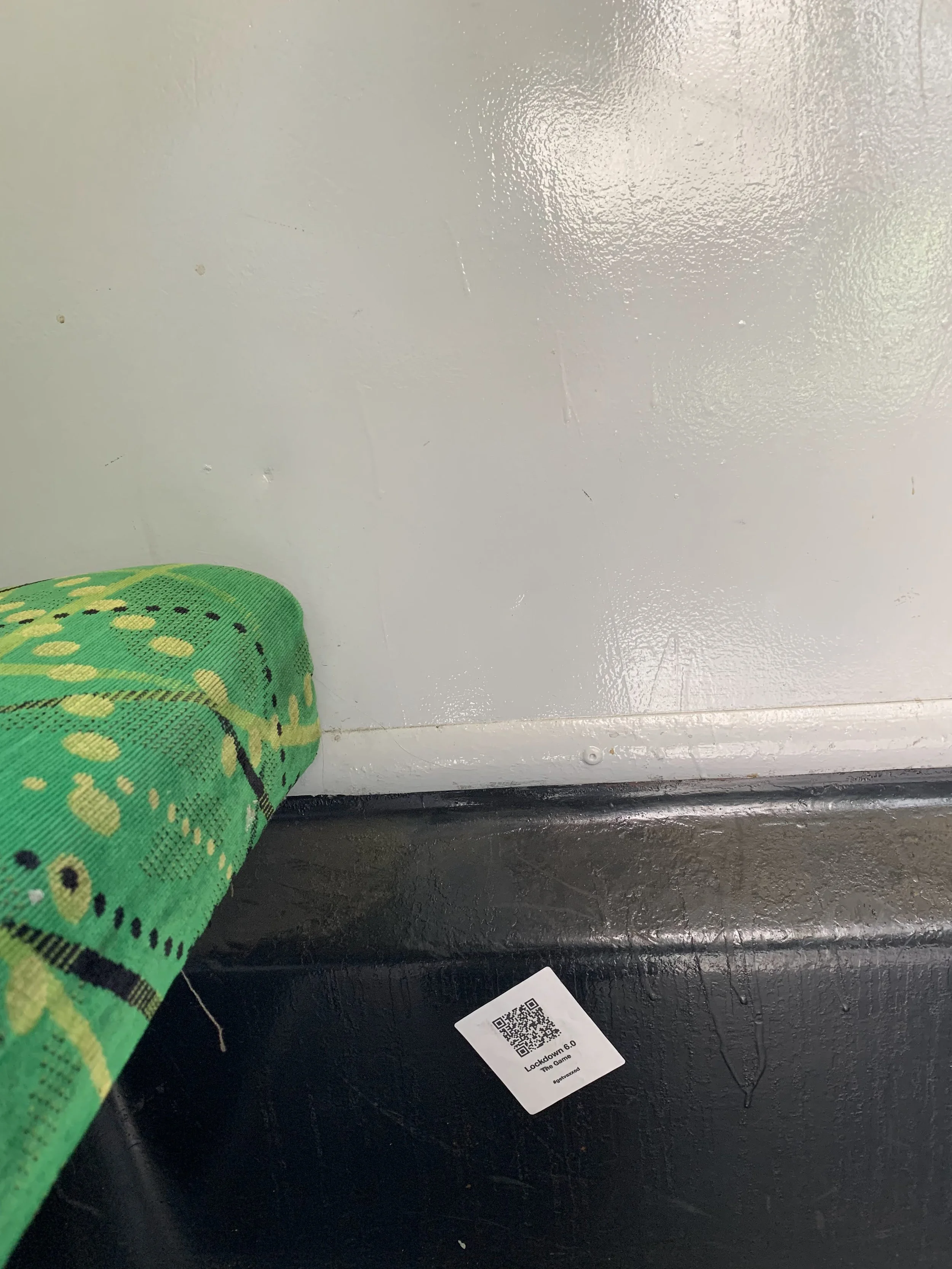  Alt text: A QR code on the wall of a tram reads: Lockdown 6.0. The Game. #getvaxxed 
