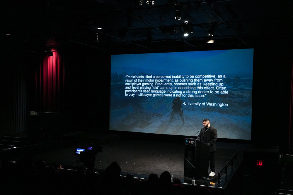  Speaker at podium with screen behind featuring a blue image with a lot of text 