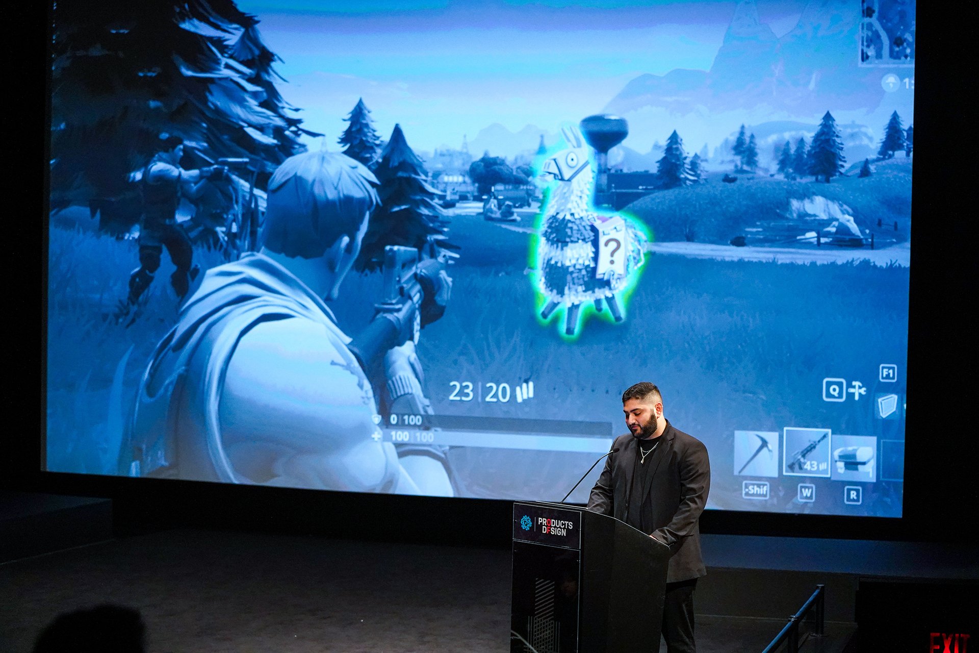  Speaker on the stage with projection of video game behind him 