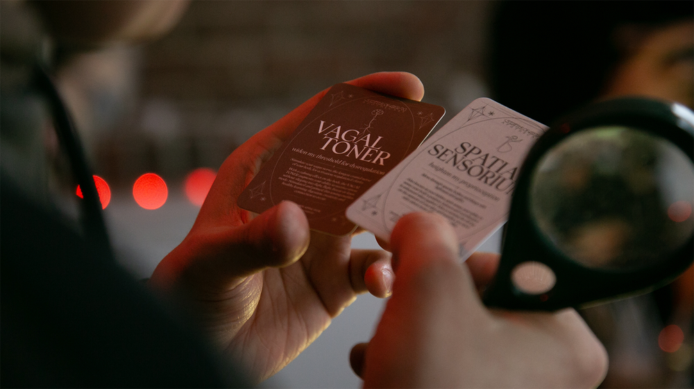  Hands holding two cards with text reading “Vagal Toner” 
