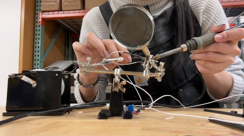   Yang soldering wires for her Arduino circuit in the Visual Futures Lab. 